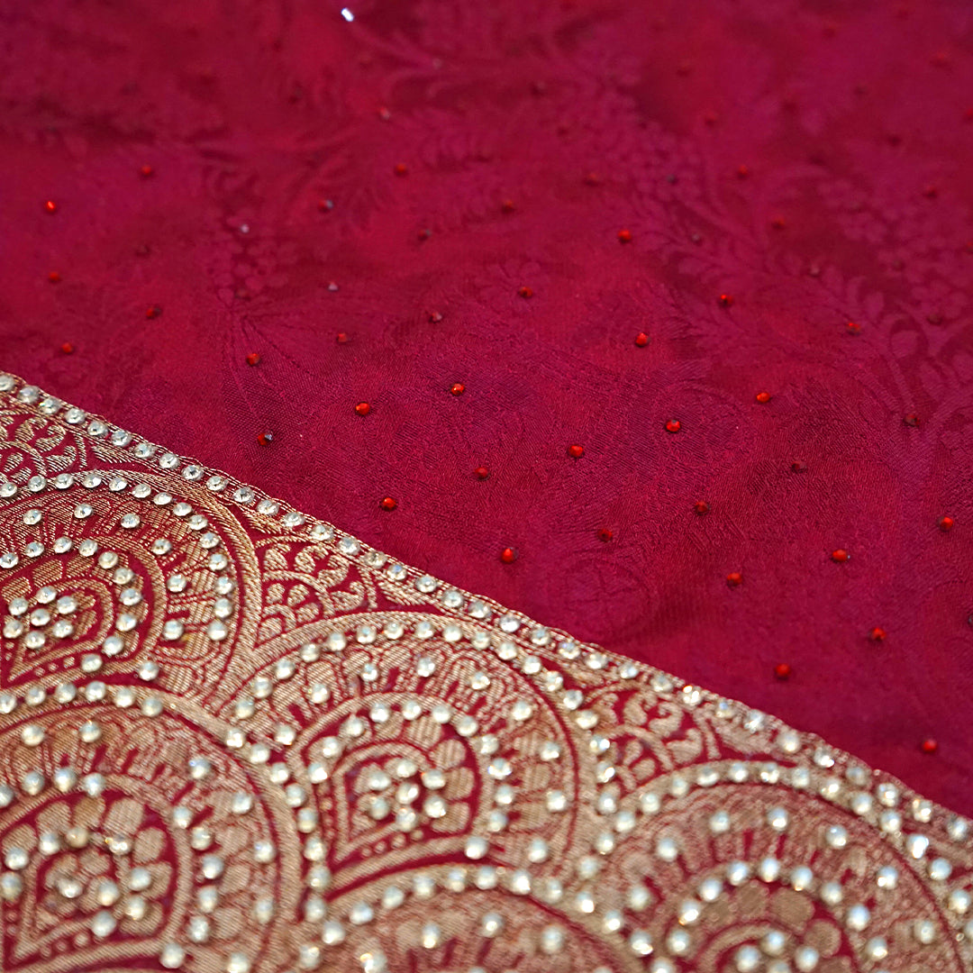 Royal Ratha Banarasi silk in deep maroon red shade, highlighted with rich golden zari motifs and an ornate golden border.