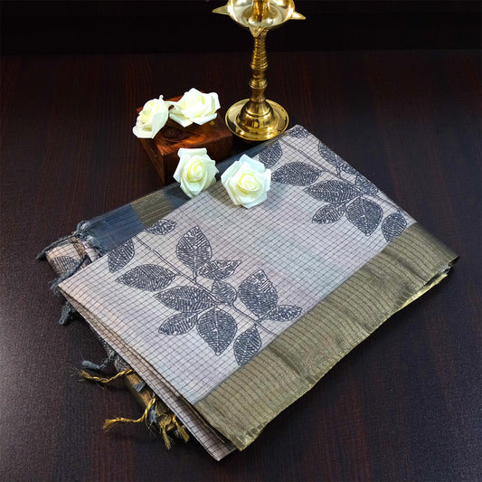 Harini Tussar in soft beige-grey base with a subtle checked pattern, beautifully accented by dark charcoal leaf motifs
