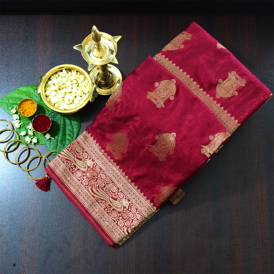 Royal Ratha Banarasi silk in deep maroon red shade, highlighted with rich golden zari motifs and an ornate golden border.