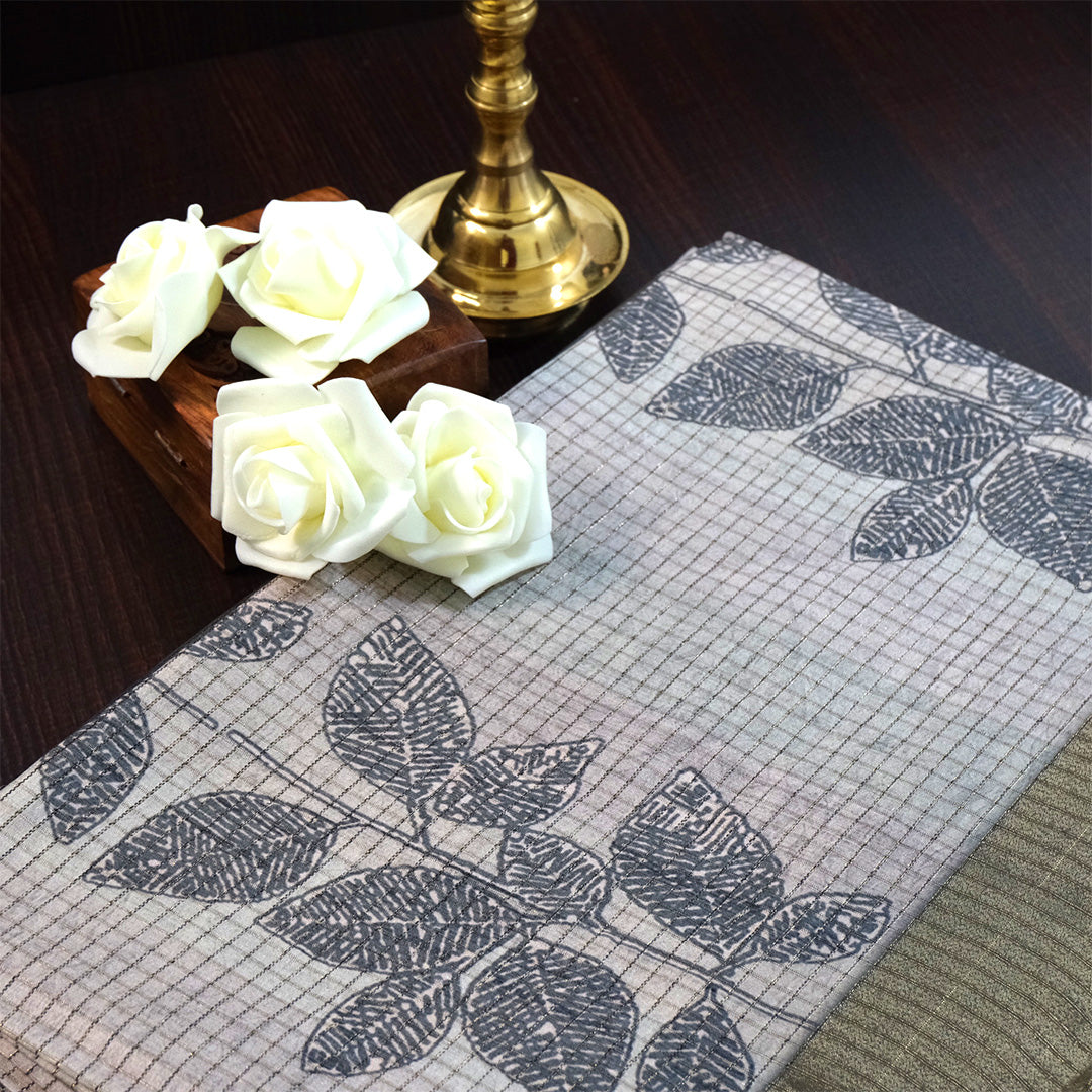 Harini Tussar in soft beige-grey base with a subtle checked pattern, beautifully accented by dark charcoal leaf motifs