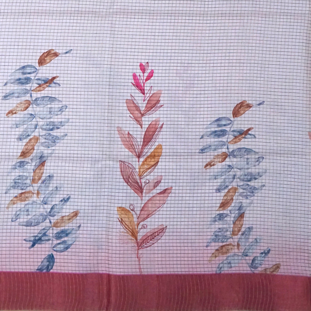 Harini Tussar in soft white base with colorful leaf motifs in blue, orange, and mustard, complemented by a rich maroon border.