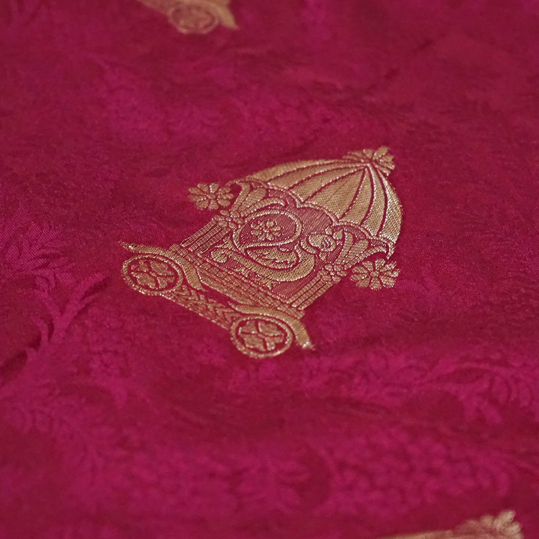 Royal Ratha Banarasi silk in deep maroon red shade, highlighted with rich golden zari motifs and an ornate golden border.