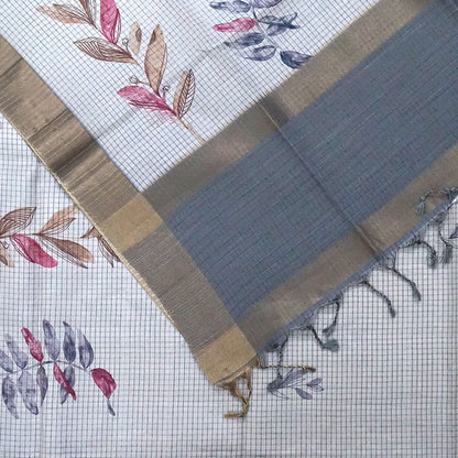 Harini Tussar in soft off-white base with multicolored leaf motifs in shades of pink, blue, and brown, beautifully complemented by an elegant metallic grey border.