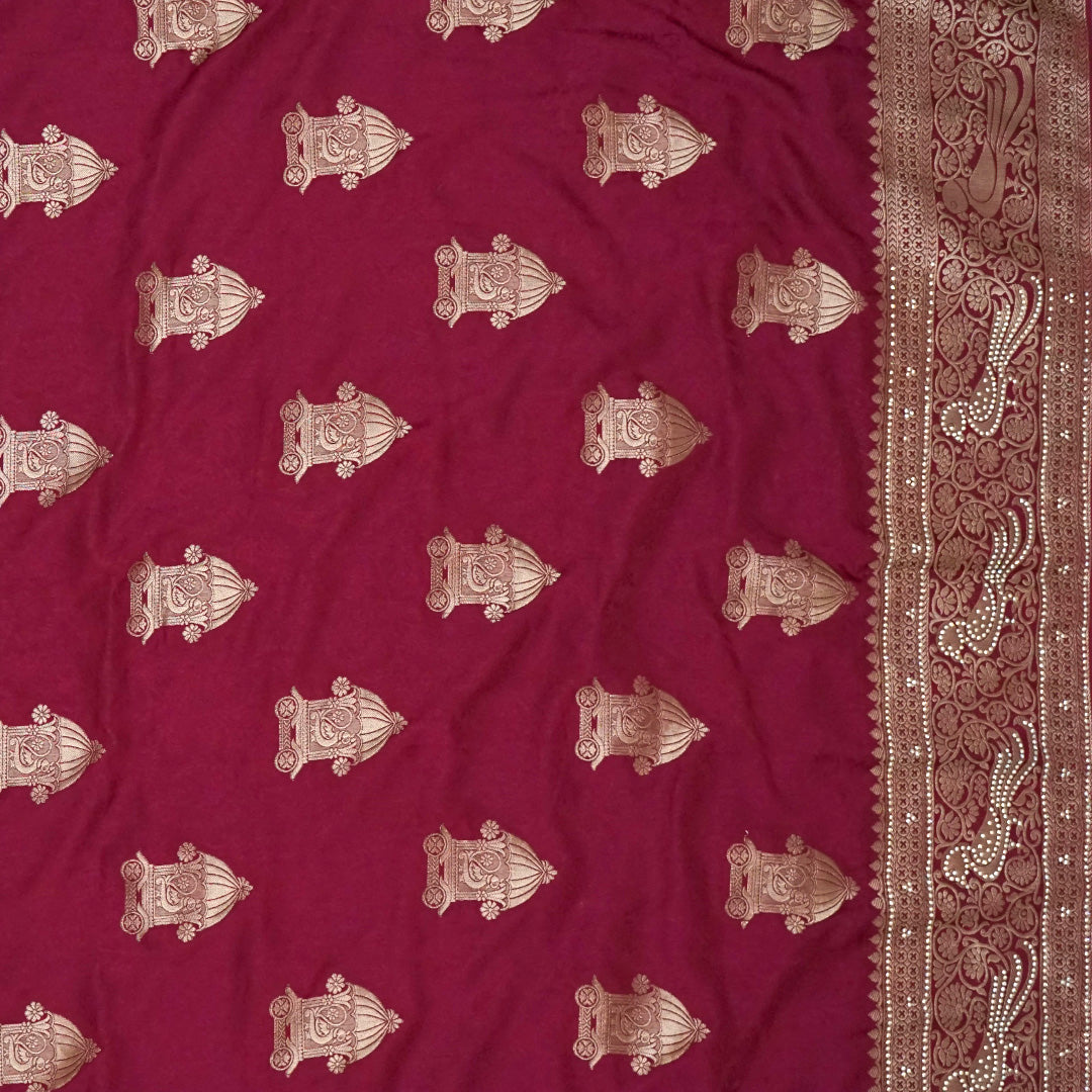 Royal Ratha Banarasi silk in deep maroon red shade, highlighted with rich golden zari motifs and an ornate golden border.