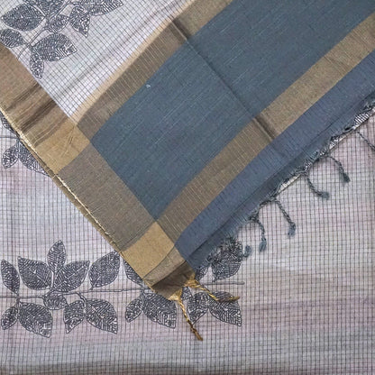 Harini Tussar in soft beige-grey base with a subtle checked pattern, beautifully accented by dark charcoal leaf motifs