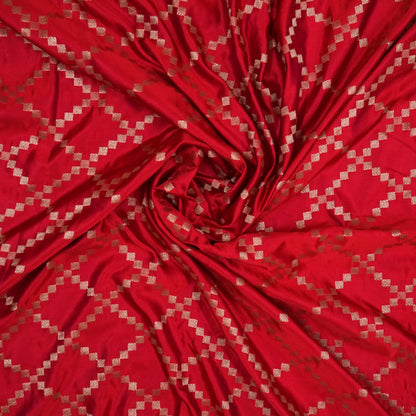 Samrudhi Silk saree in vibrant crimson red with a shimmering copper-toned border.