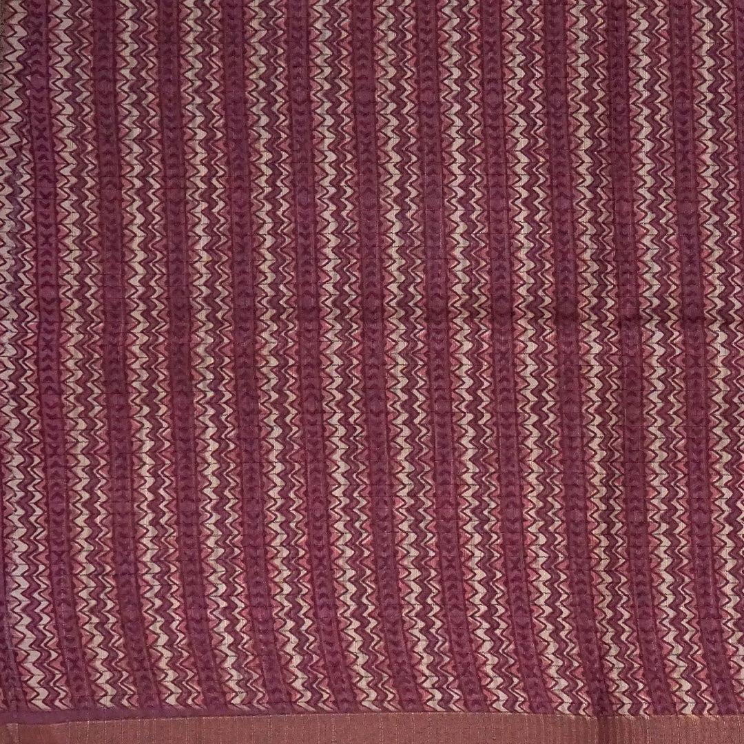 Harini Tussar in soft beige base with maroon leaf motifs and a matching brownish-maroon border, creating an elegant and earthy look.