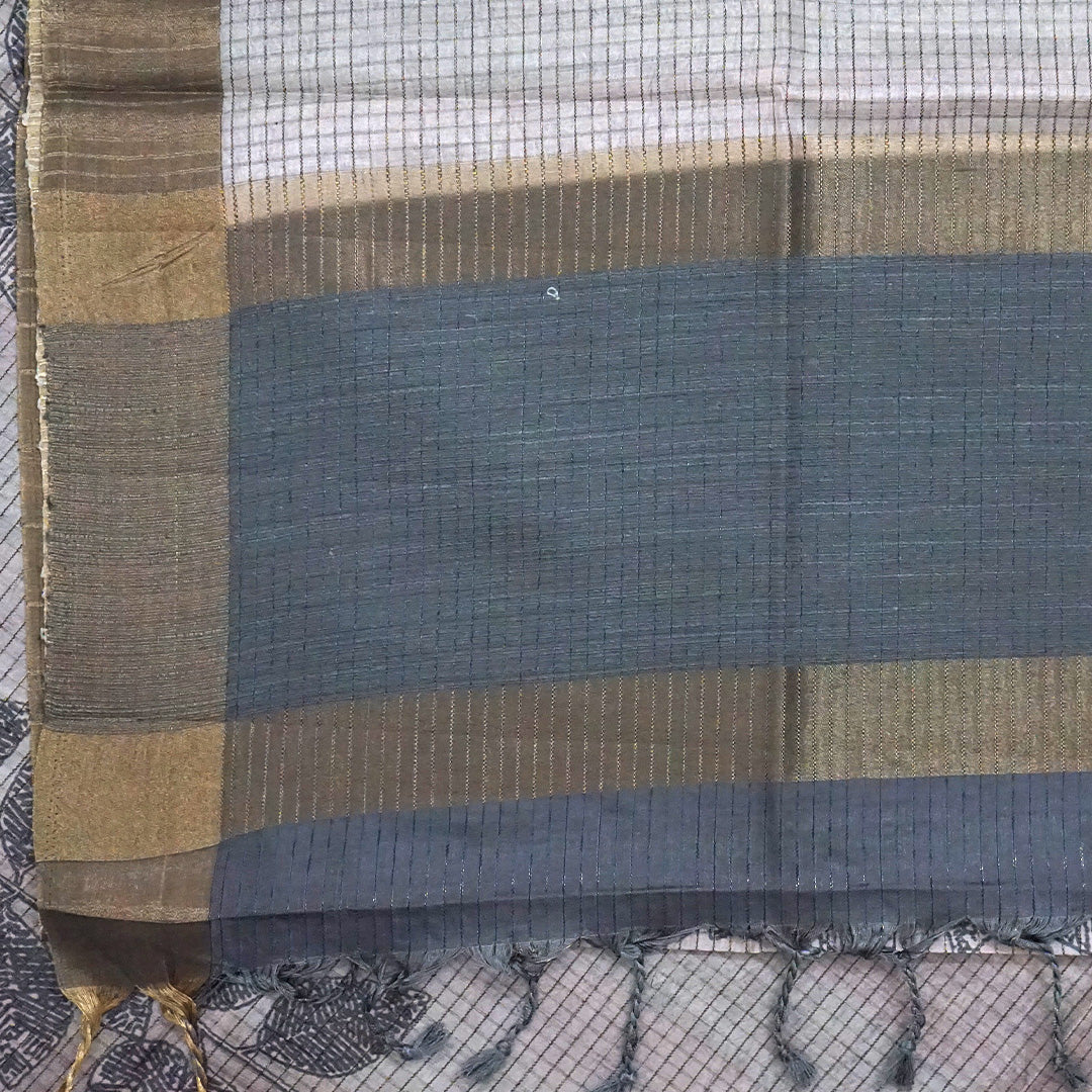 Harini Tussar in soft beige-grey base with a subtle checked pattern, beautifully accented by dark charcoal leaf motifs