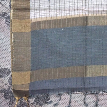 Harini Tussar in soft off-white base with multicolored leaf motifs in shades of pink, blue, and brown, beautifully complemented by an elegant metallic grey border.