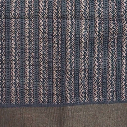 Harini Tussar in soft beige-grey base with a subtle checked pattern, beautifully accented by dark charcoal leaf motifs