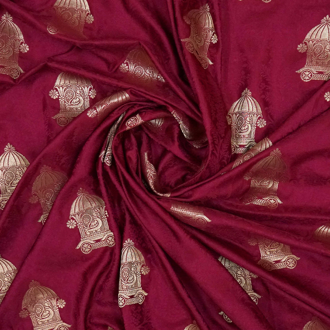 Royal Ratha Banarasi silk in deep maroon red shade, highlighted with rich golden zari motifs and an ornate golden border.