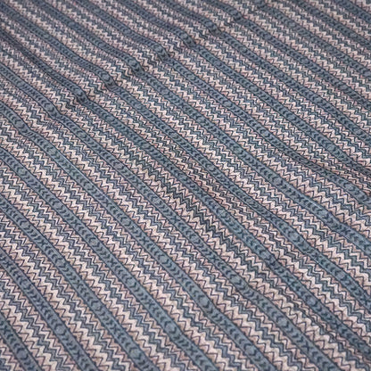 Harini Tussar in soft off-white base with multicolored leaf motifs in shades of pink, blue, and brown, beautifully complemented by an elegant metallic grey border.