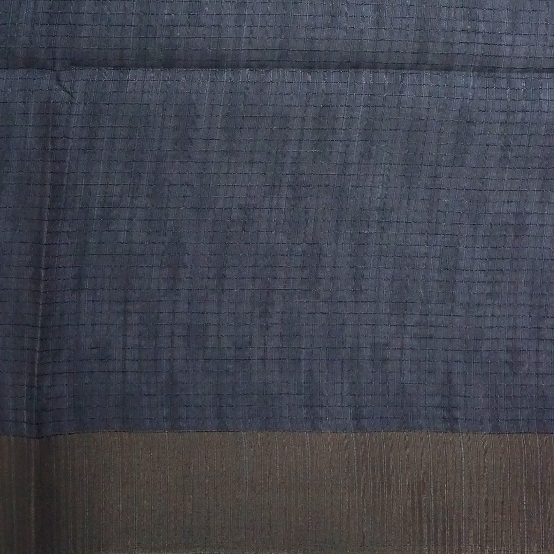 Harini Tussar in soft off-white base with multicolored leaf motifs in shades of pink, blue, and brown, beautifully complemented by an elegant metallic grey border.