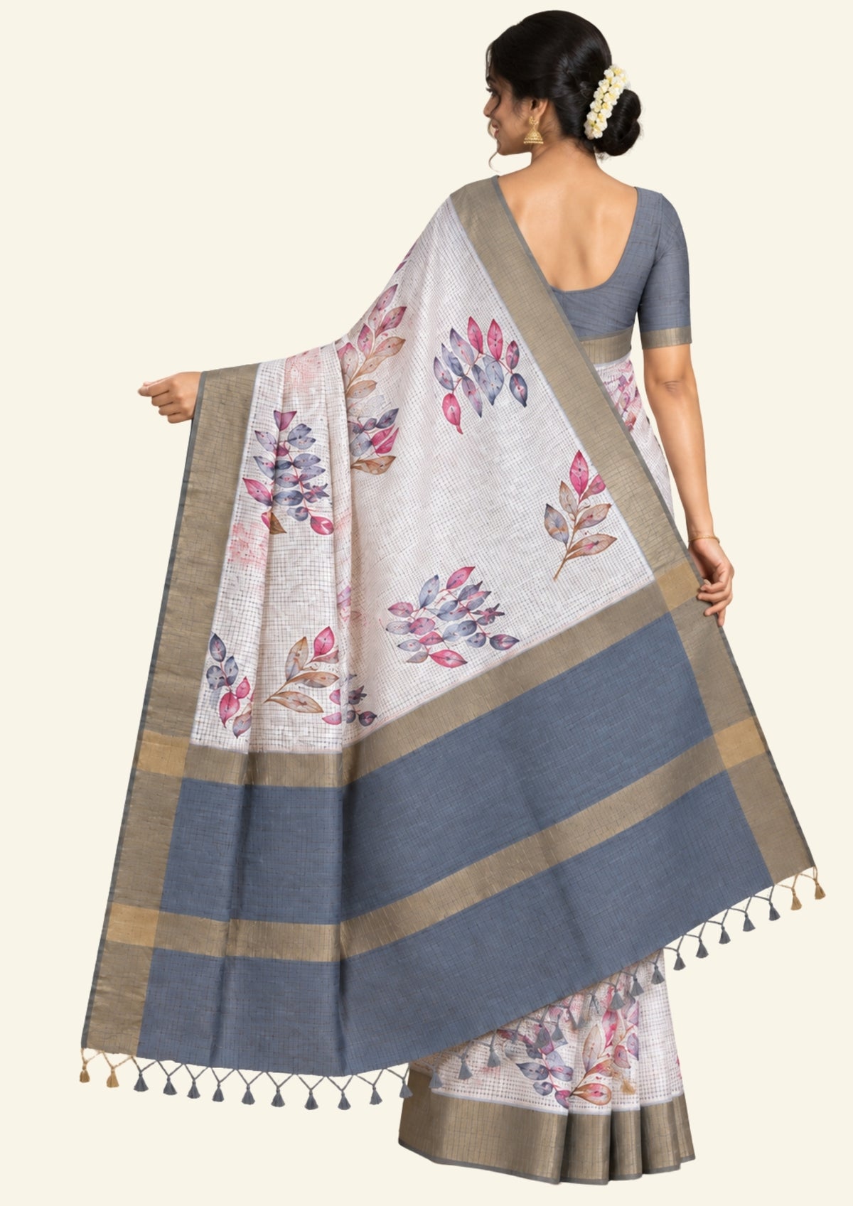 Harini Tussar in soft off-white base with multicolored leaf motifs in shades of pink, blue, and brown, beautifully complemented by an elegant metallic grey border.